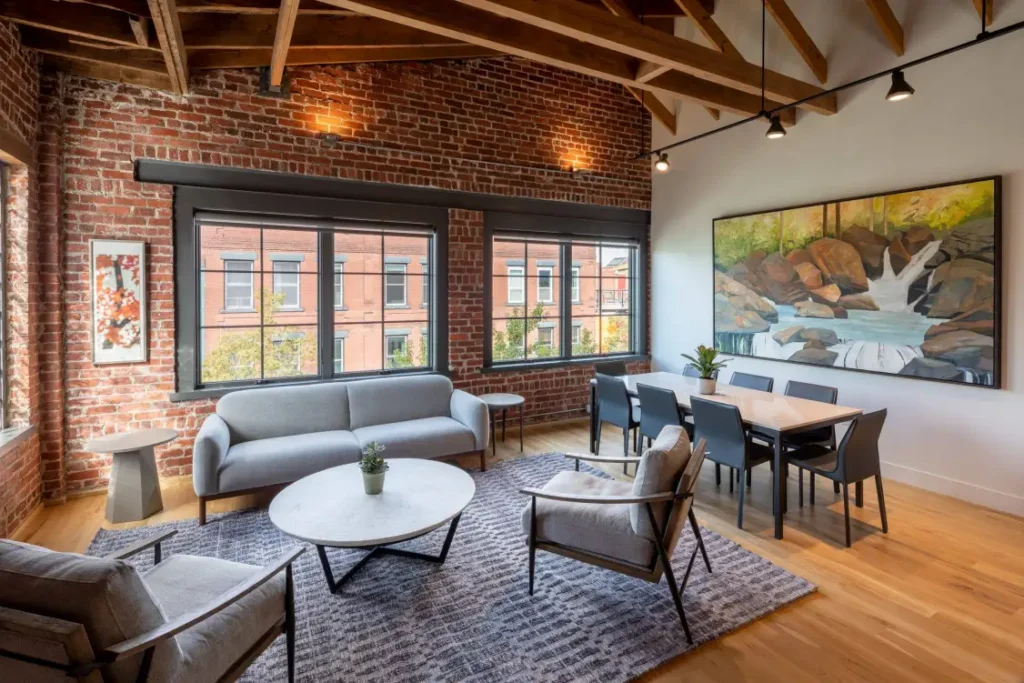 Unit 303 spacious living and dining area with exposed brick wall, Broadway views and original artwork, Elevation Lofts Hotel Asheville NC